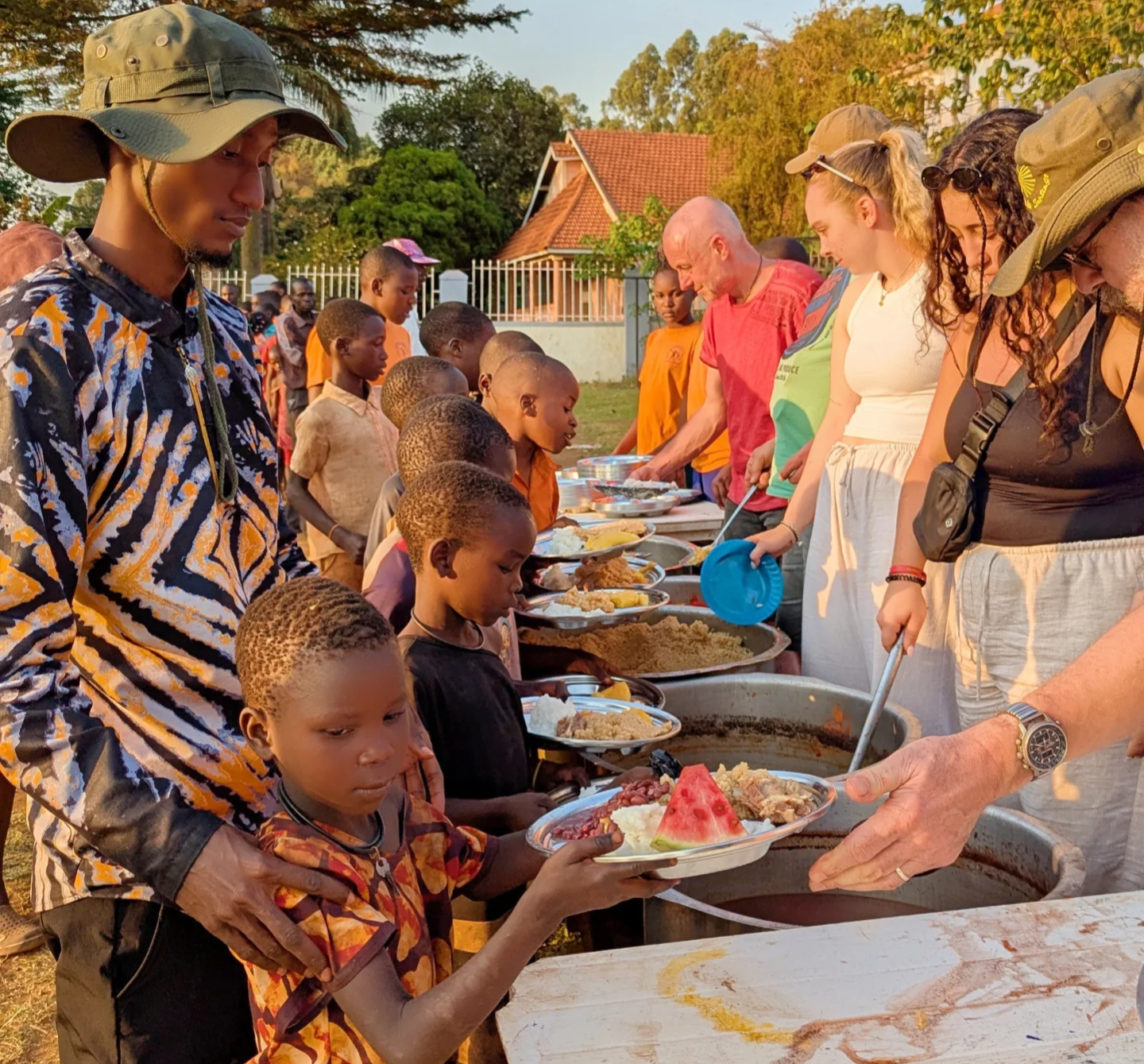 Volunteers serving food to children in Uganda
